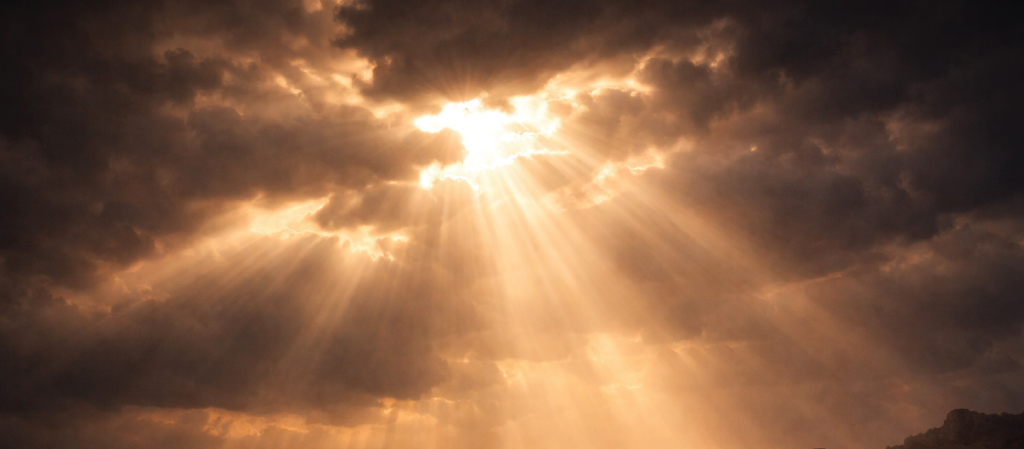 Golden light breaking through dark clouds.