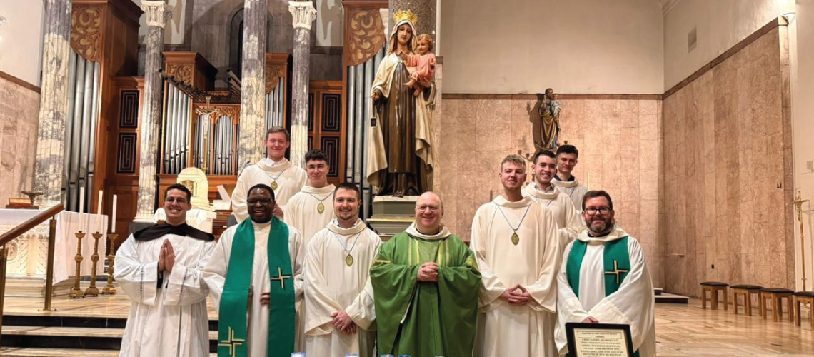 Newly appointed altar servers pose for a photo at Whitefriar Street Church in front of a statute of Our Lady of Mount Carmel.